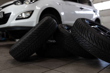 Car in a garage for maintenance, oil, tyre change (shallow DOF; color toned image)