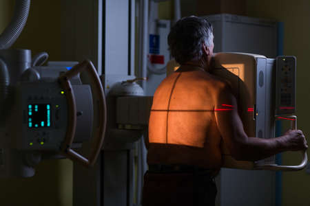 Pretty, young woman goiing through a Computerized Axial Tomography (CAT) Scan medical test / examination in a modern hospital (color toned image; shallow DOF)の写真素材