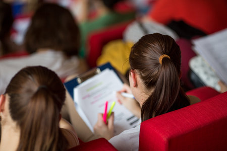 University students sitting in class, taking notesの写真素材