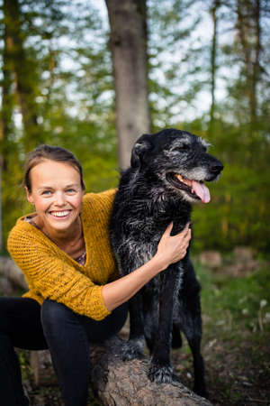 Young woman with her favorite black dogの写真素材
