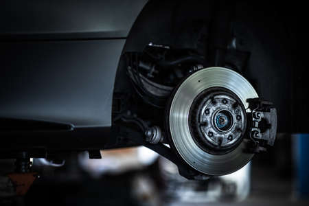Tire change - wheel balancing or repair and change car tire at auto service garage or workshop by mechanicの写真素材