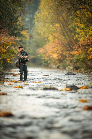 Fly fisherman fly fishing on a splendid mountain riverの写真素材