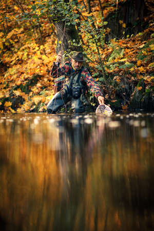 Fly fisherman fly fishing on a splendid mountain riverの写真素材
