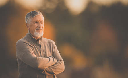 Portrait of handsome senior man in the autumn outdoors. Active senior enjoying his retirement in the natureの写真素材