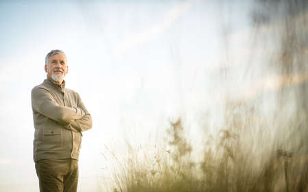 Portrait of handsome senior man in the autumn outdoors. Active senior enjoying his retirement in the natureの写真素材