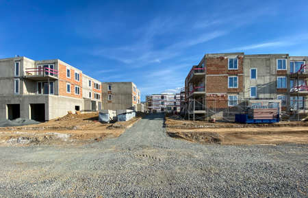 Modern and new apartment building. Multistoried modern, new and stylish living block of flats. Selective DOF, focus on the grass with blurred buildings in the background (ample copy space)の写真素材