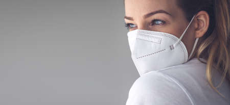 Young woman wearing a face mask during cvirus and flu outbreak. Virus and illness protection, home quarantine.  conceptの写真素材