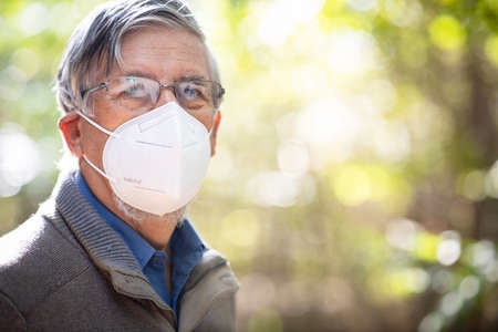 Senior man with glasses fogged due to condensation caused by the use of a face mask, respiratorの写真素材