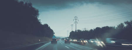Cars on a highway at a rainy dusk (shallow DOF; color toned image)の写真素材