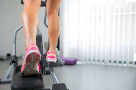 Young woman's muscular legs on stepper/treadmill, closeupの写真素材