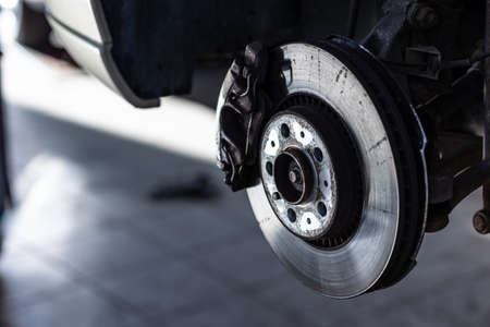 Car in a garage for maintenance, oil/tyre change (shallow DOF; color toned image)の写真素材