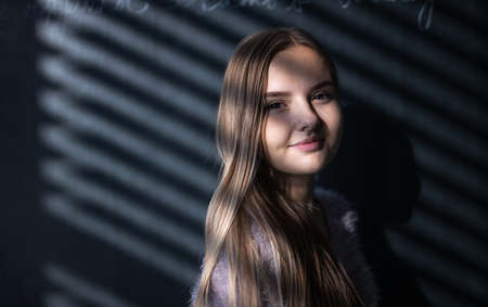 Pretty, young female student in front of a blackboard during classの写真素材