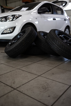 Car in a garage for maintenance, oil / tire change (shallow DOF; color toned image)の写真素材