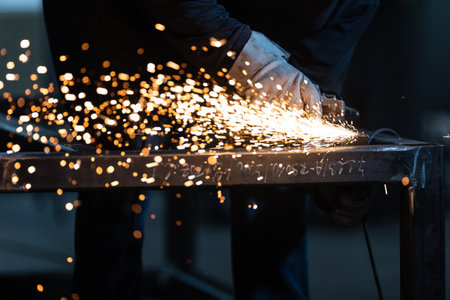 Man working on iron with grinder. Man at work. Sparkles and fire from grinder cutting. Grinder. Worker.の写真素材