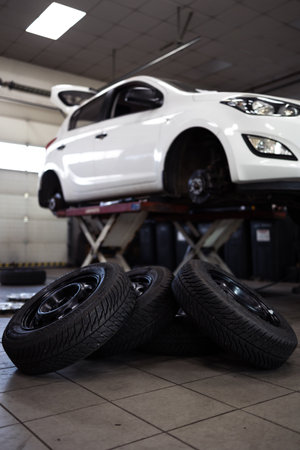 Car in a garage for maintenance, oil, tire change (shallow DOF; color toned image)の写真素材
