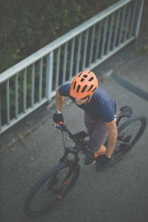 Young man with his mountain bike going for a ride past the city limits in a lovely forest, getting the daily cardioの写真素材