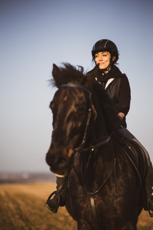 Female horse rider riding outdoors on her lovely horseの写真素材