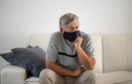 Senior man wearing  a facemask during coronavirus and flu outbreak. Virus and illness protection, home quarantine. COVID-19 conceptの写真素材