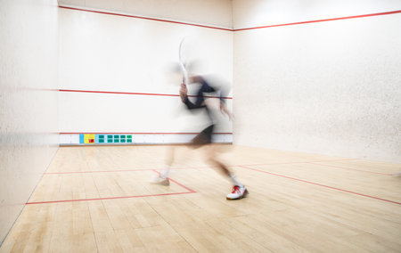 Squash player in action on a squash court (motion blurred image; color toned image)の写真素材
