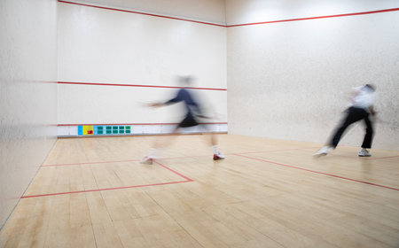 Squash players in action on a squash court (motion blurred image; color toned image)の写真素材