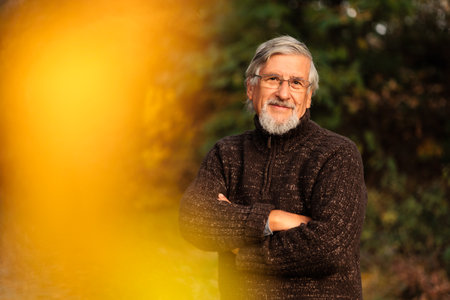 Elderly Caucasian male walking outdoors on an autumn, fall dayの写真素材