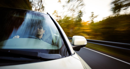 Young man at the steering wheel of his car commuting to workの写真素材
