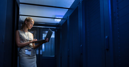 IT engineer standing in front of working server rack doing routine maintenance check and diagnostics...