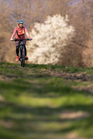 Pretty, young woman with her mountain bike going for a ride past the city limits, getting the daily dose of cardioの写真素材