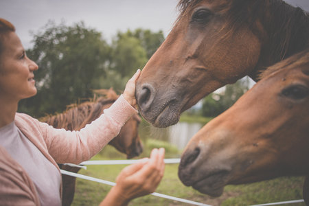 Pretty, young, redhead woman with her lovely horse, during her favorite leisureの写真素材