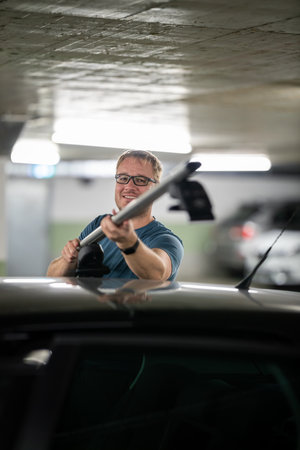 Handsome young driver getting ready to go biking - putting a bike rack on the roof of his carの写真素材