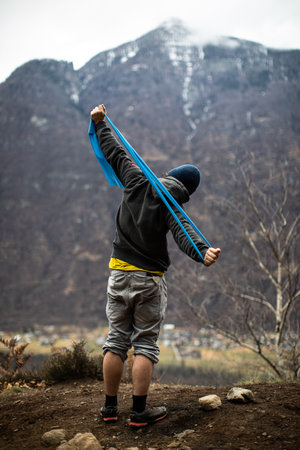 A rock climber climbing on a boulder rock outdoors. Group of friends involved in sports outside.の写真素材