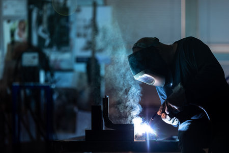 Man working on iron with grinder. Man at work. Sparkles and fire from grinder cutting. Grinder. Worker.の写真素材