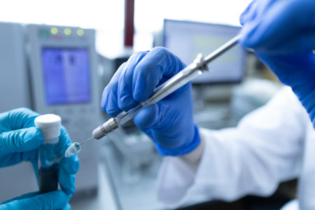 Scientist injecting a sample via the autosampler of HPLC system. High performance liquid chromatography at chemical laboratory. Developing of pharmaceuticals or vaccines. Biochemistry analysisの写真素材