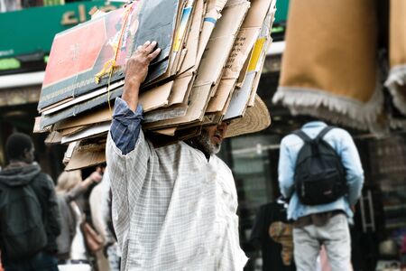 Poor man who works by transporting used cartons to Morocco which he will use as a sales counter