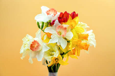 A bouquet of multicolored wildflowers on a neutral orange background. Perfect shot for spring, women's day and botany.の写真素材