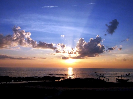 The sun is setting , creating rays of light and beaituful orange and deep blue hues                             の写真素材