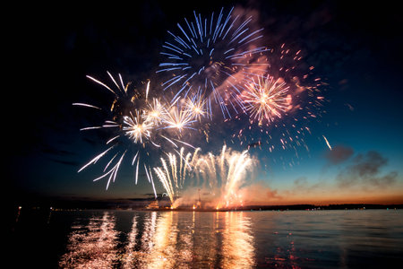 Holiday fireworks above water with reflection on the black sky backgroundの写真素材