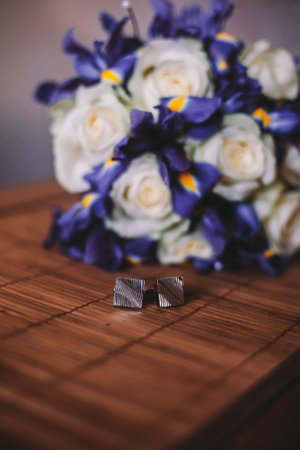 Wedding details rings and grooms bouquet on the tableの写真素材