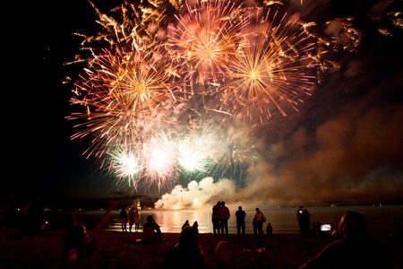 Holiday fireworks above water with reflection on the black sky backgroundの写真素材