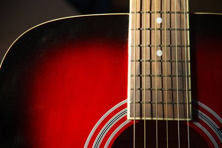 Close up view of a Part of a red acoustic guitar on black backgroun with a small Depth of fieldの写真素材