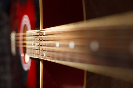 Close up view of a Part of a red acoustic guitar on black backgroun with a small Depth of fieldの写真素材