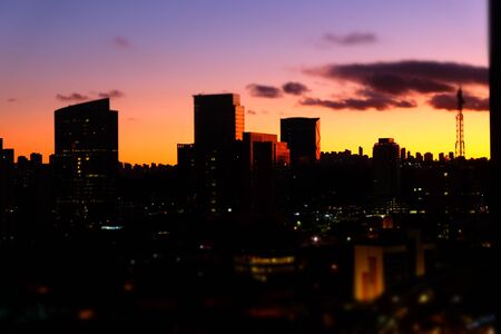 Flat cityscape with pink sky, white clouds and sunset or sunrise. Modern city skyline flat panoramic background. Urban city tower skyline illustrationの写真素材
