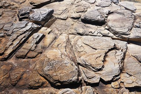The texture of stone of the rock on a sunny day with the micro shadows