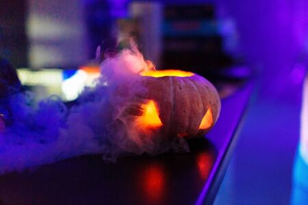 Halloween pumpkin face lantern at night with misty smoke. Halloween background.の写真素材
