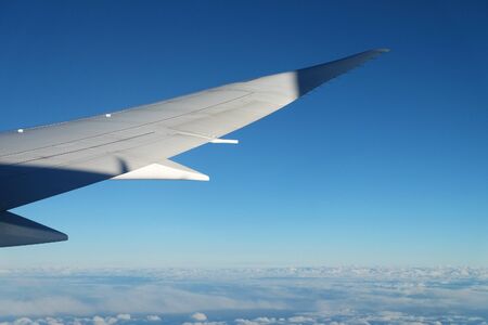 View from airplane window with sky and white clouds at noonの写真素材