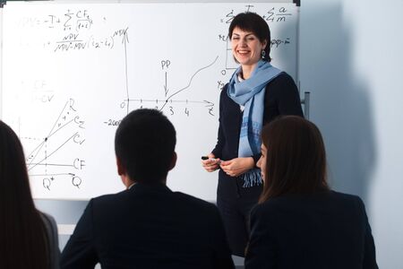 2016.01.17 Business school training in the Samara State University. Portrait of happy teacher standing in classroom talking with students and explaining subjectのeditorial素材