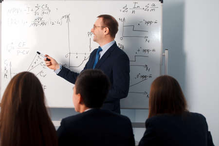 2016.01.17 Business school training in the Samara State University. People and education. Teacher showing graph on blackboard during lesson..のeditorial素材