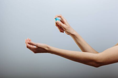 Hand of lady that applying alcohol spray or anti bacteria spray to prevent spread of germs, bacteria...