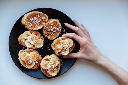 Hand is holding homemade fruit cake for breakfast on the ceramic plate. Top view. selective Focus.の写真素材