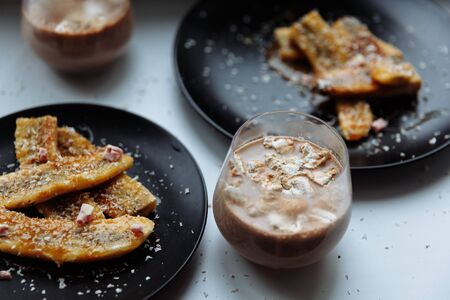 Fried Banana dessert and chocolate smoothie milk glass on white table. Selective focus.の写真素材